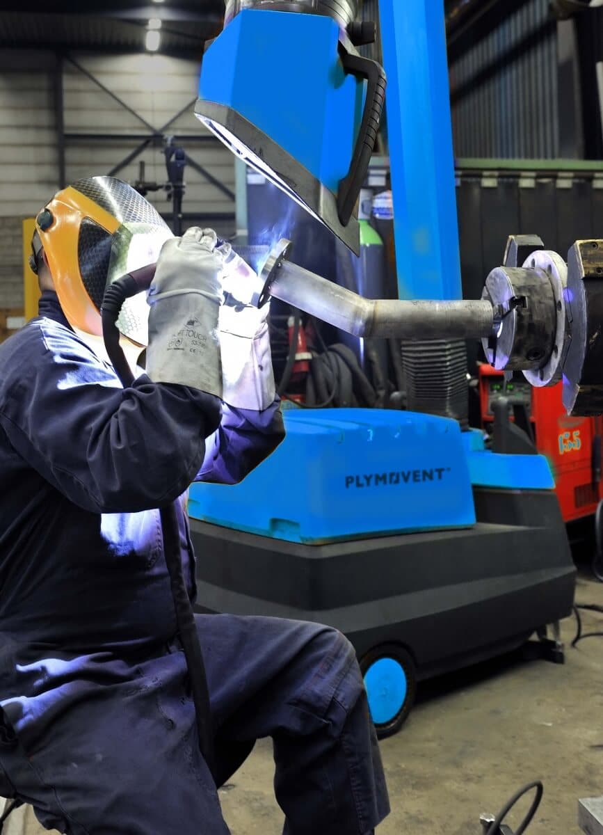 Man welding using a blue Plymovent Portable Fume Extractor.