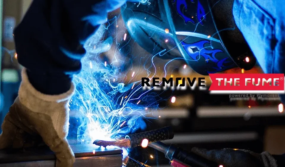 A close up shot of a man welding with a welding mas on while harmful fumes are being generated.