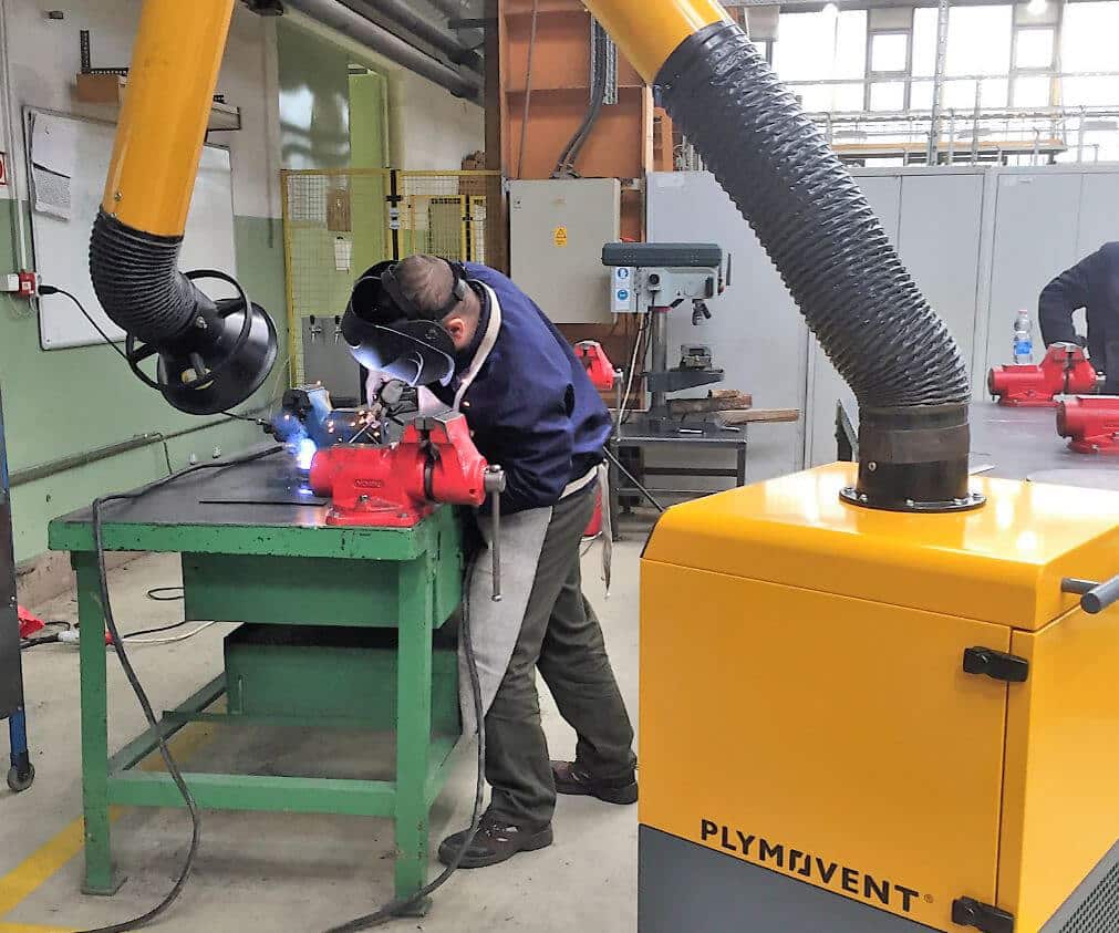 Man using PPE to welding including a Plymovent portable fume extractor.